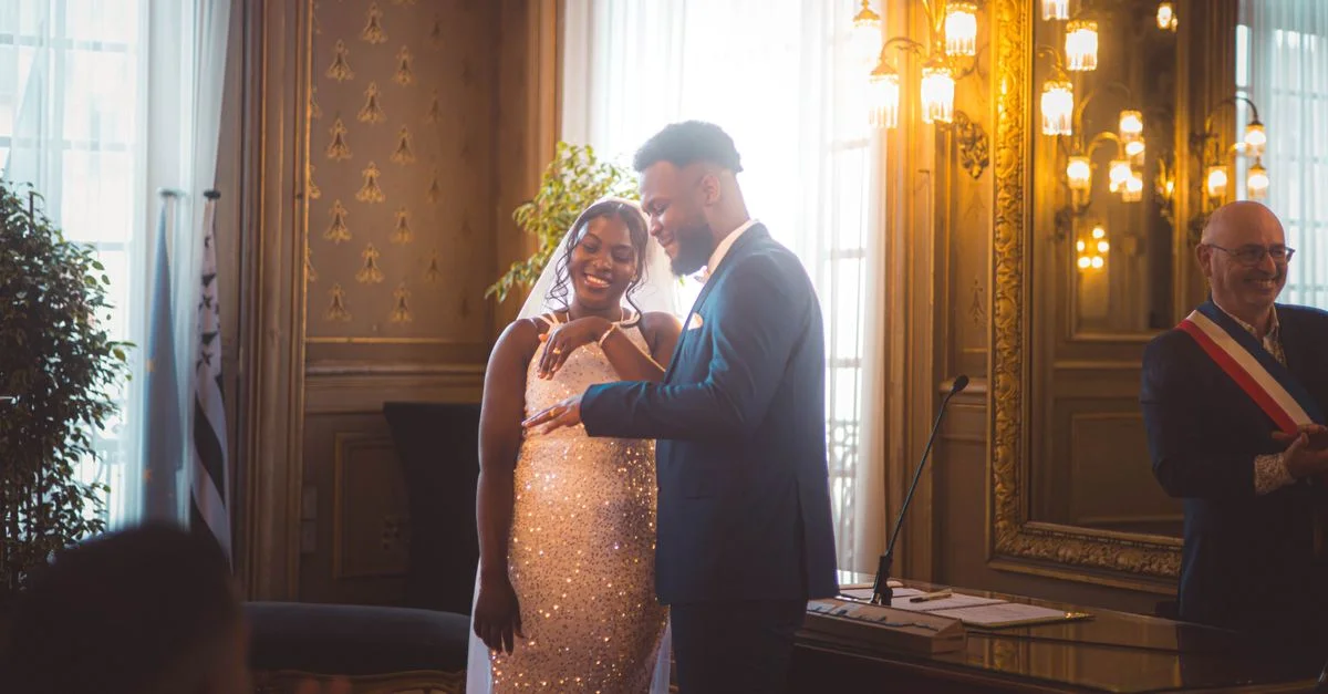 Cérémonie de mariage élégante avec un couple échangeant des alliances à l'intérieur.